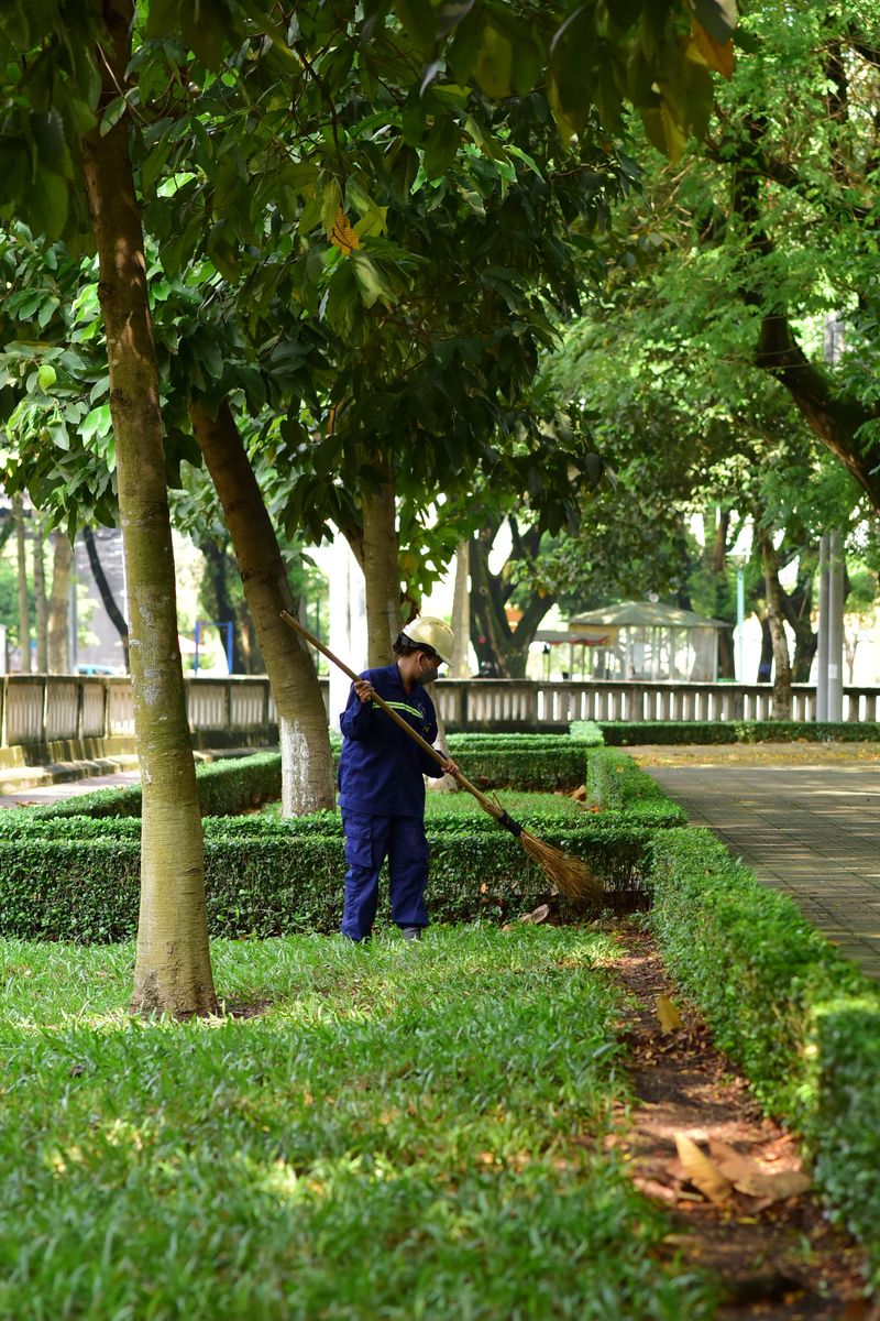 Gardener raking leaves and debris in a yard